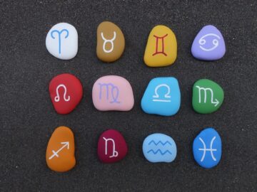 Astrological zodiac chinese signs painted and graved on stones over black volcanic sand