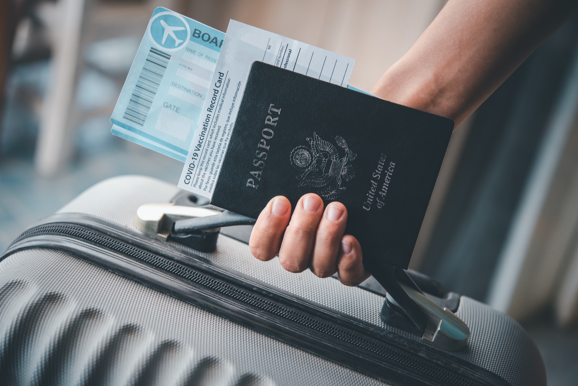 People holding passports and Coronavirus vaccination record card