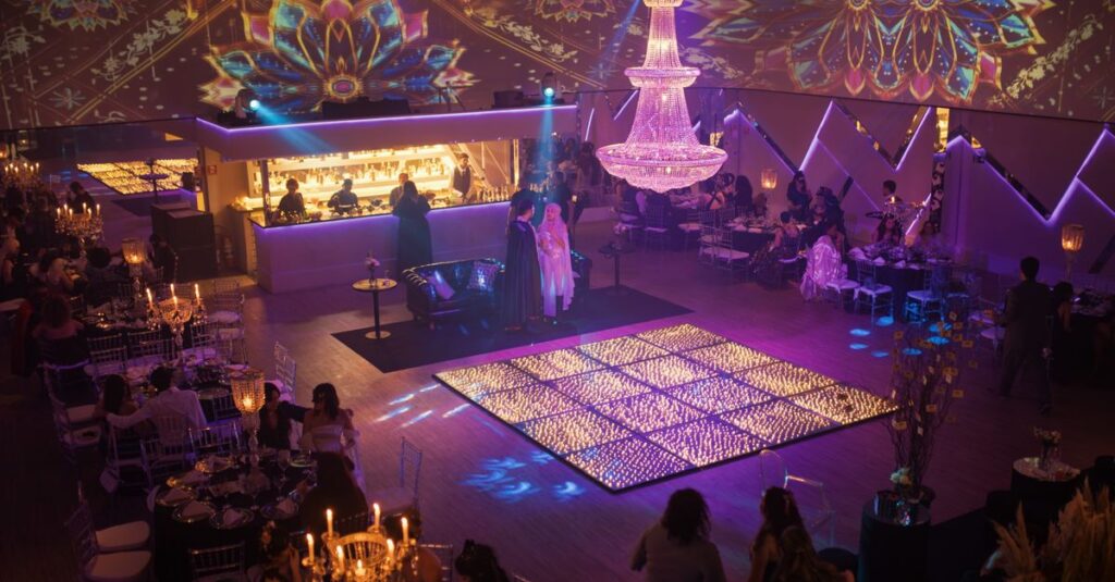 Móveis LED para eventos: por que essa tendência conquistou empresas e produtores Imagem de um evento social com mesas decoradas e um grande lustre iluminado